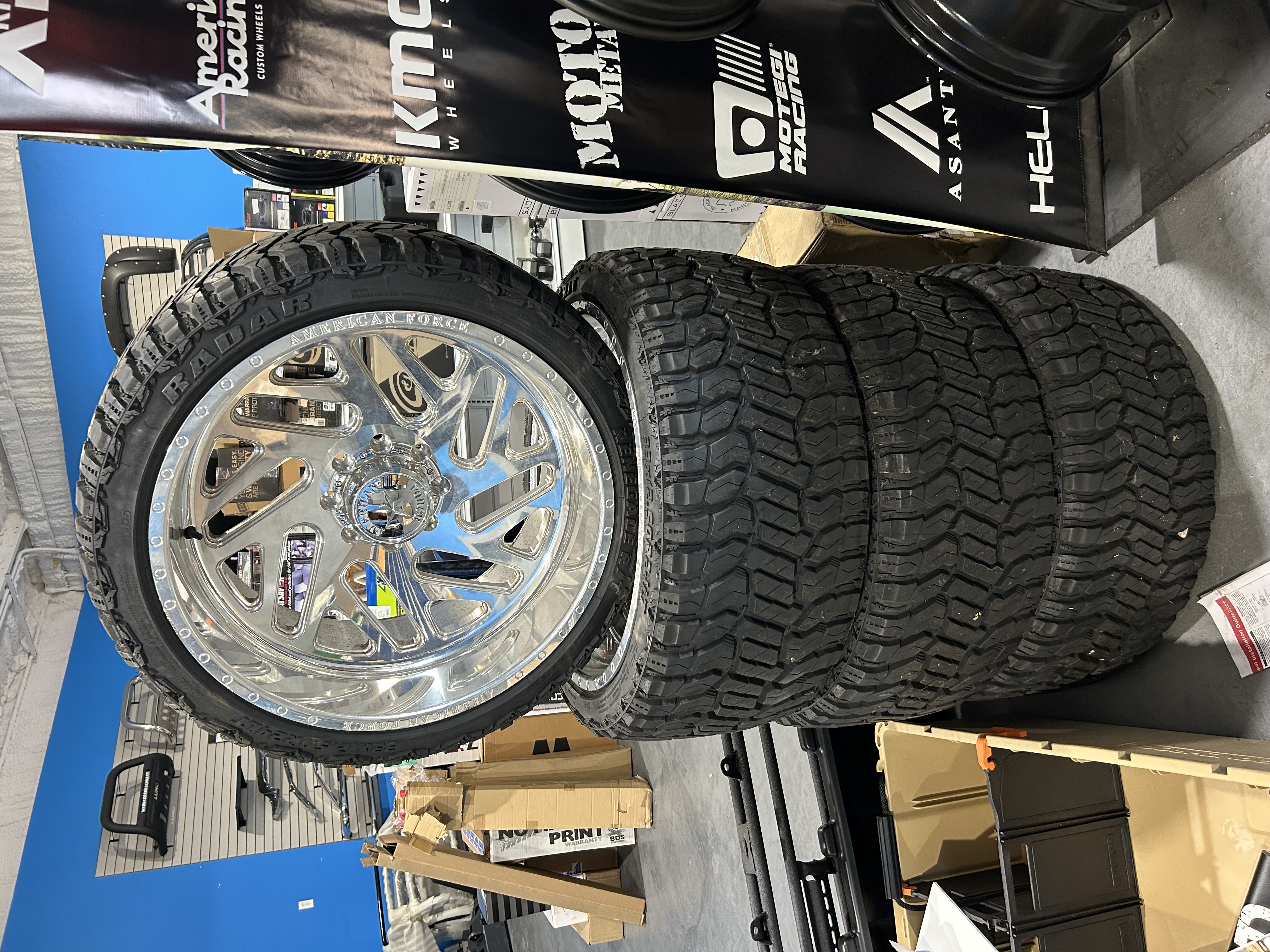 Chrome American Forged wheels mounted with mud terrain tires, with KMC, Moto Metal, Motegi Racing, and Asanti brand banners