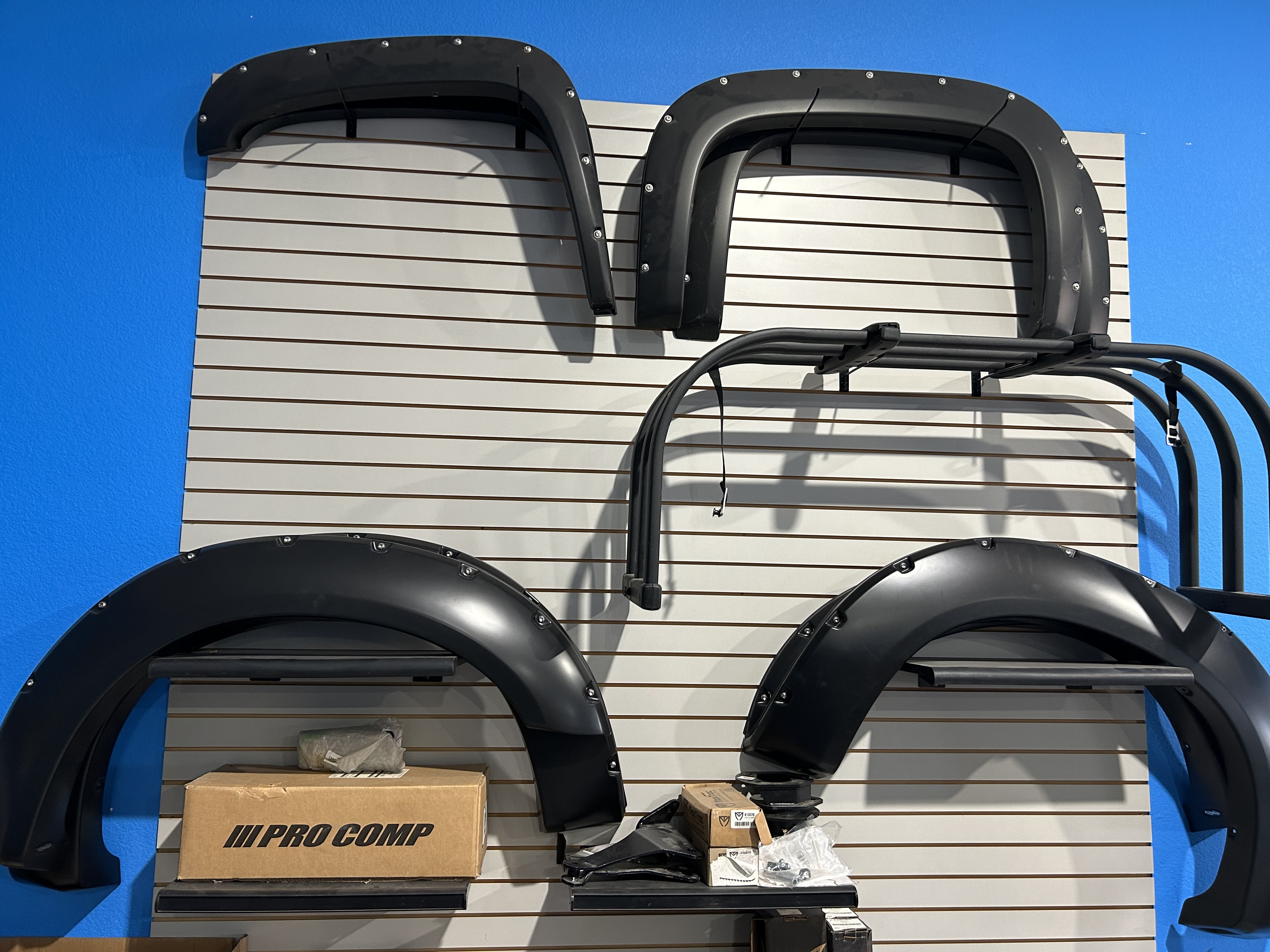 Pro Comp fender flares and rear cab racks displayed on slatwall at Truck Country Outfitters