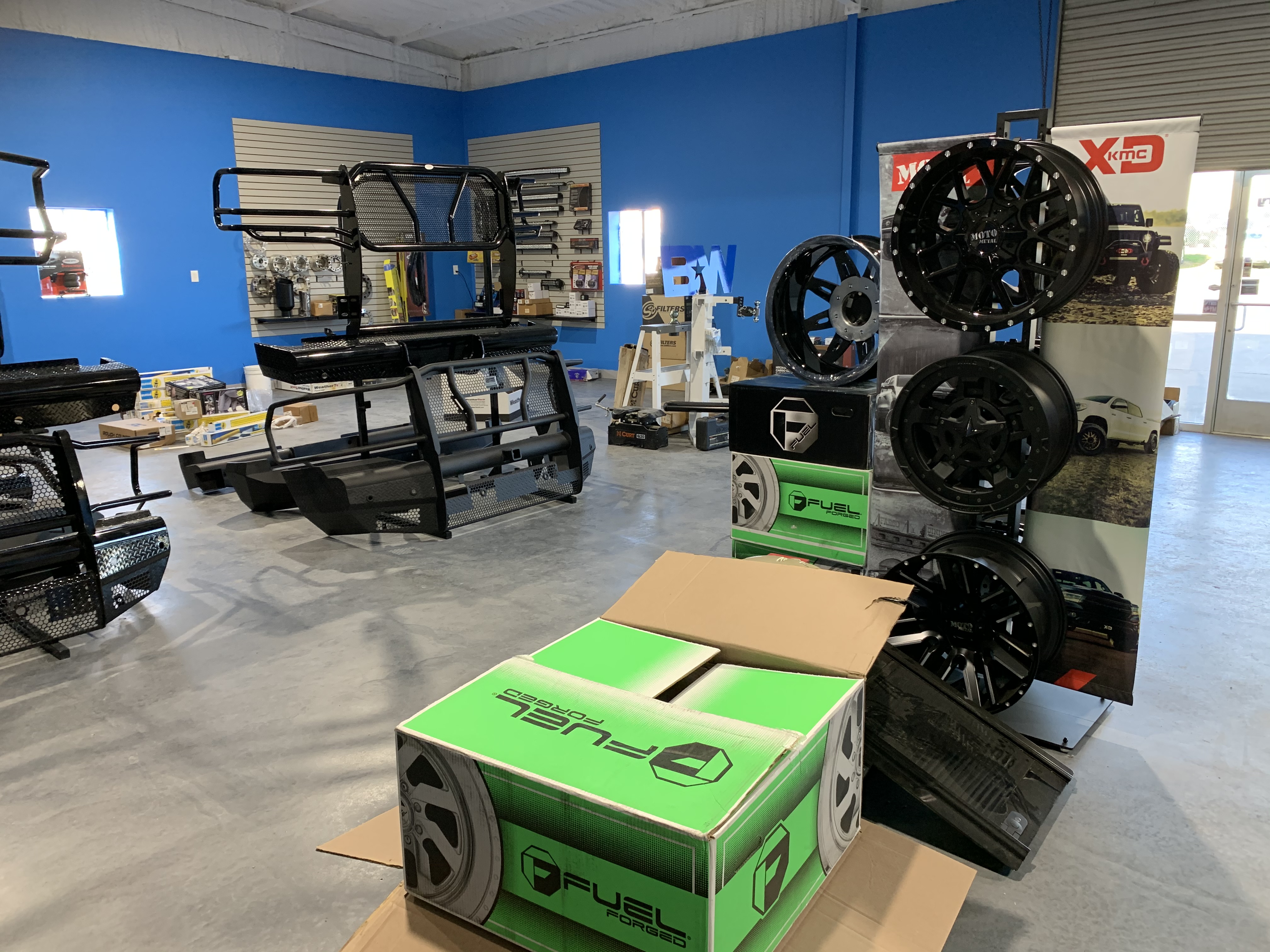 Showroom with Fuel Forged wheel boxes, headache racks, and bench grille guards — Truck Country Outfitters