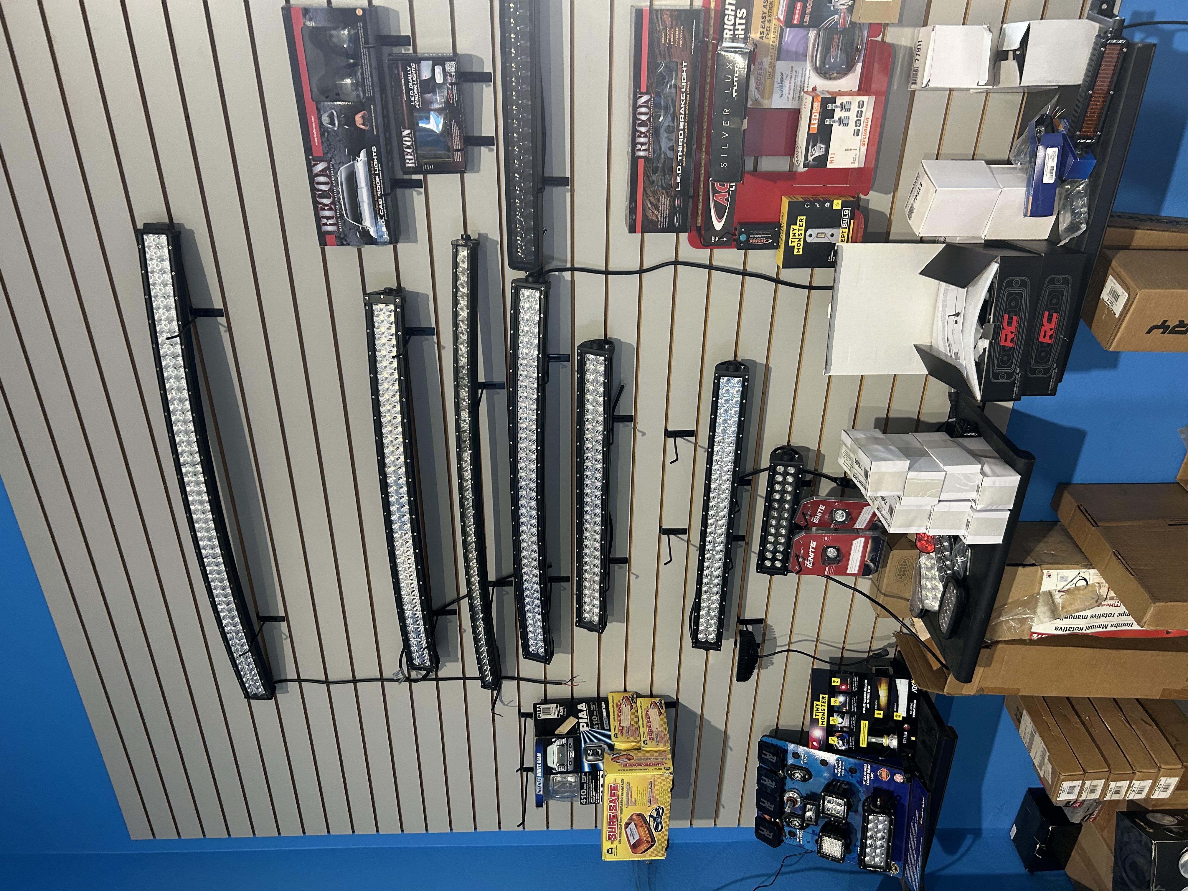 LED light bar display wall at Truck Country Outfitters — RECON, PIAA curved and straight bars, pod lights, and off-road driving lights